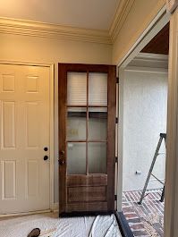 A room with a door and a ladder in it.