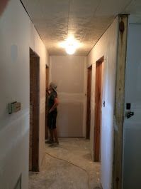 A man is standing in a hallway between two doors.