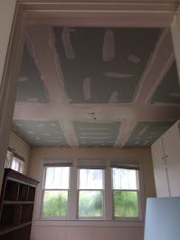 A room with a ceiling that is being remodeled and a lot of windows.