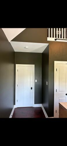 A hallway with a staircase and a door in a house.