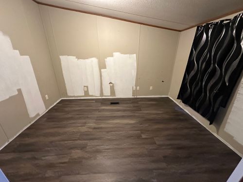 An empty room with hardwood floors and white walls.