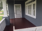 There is a porch swing on the porch of a house.