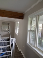 A room with a ladder and a lot of windows.