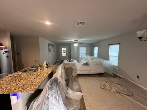 A living room with a couch , a sink , and a ceiling fan.