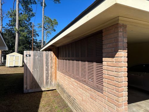 A brick building with a wooden fence in front of it.
