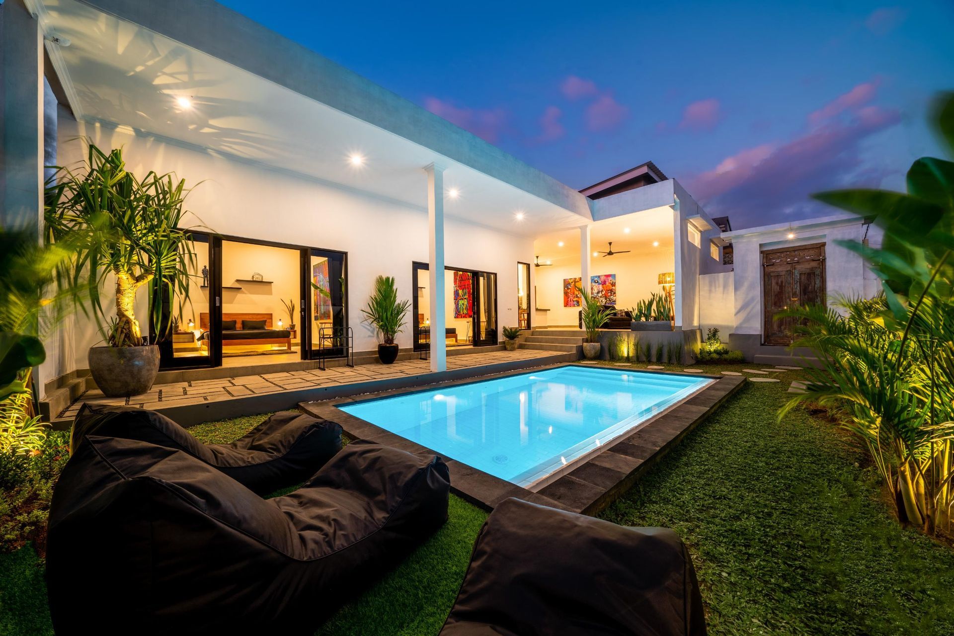 There is a large swimming pool in the backyard of a house.