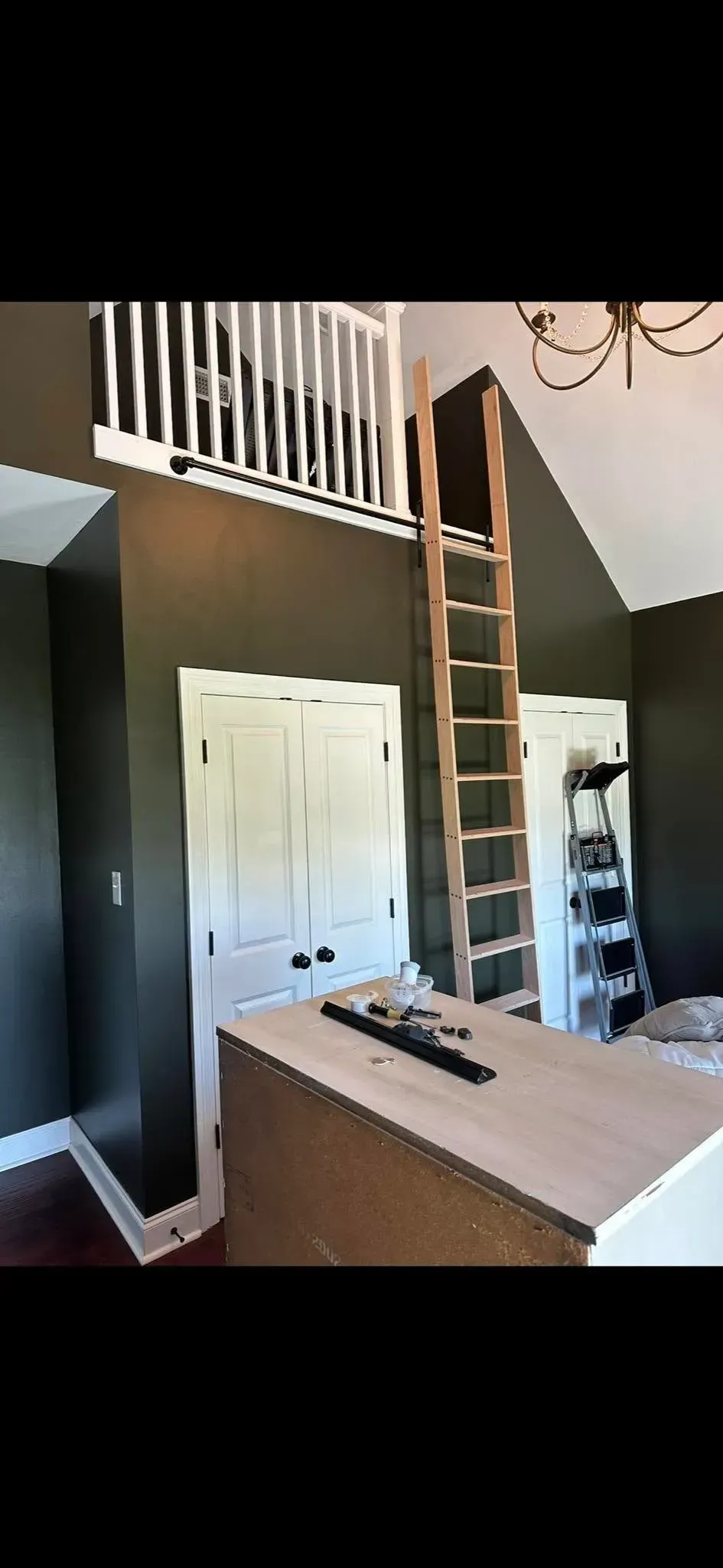 A room with a ladder going up to the second floor.
