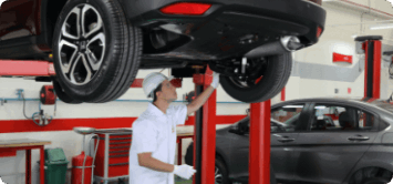 Um homem de terno está segurando um tablet na frente de um carro.