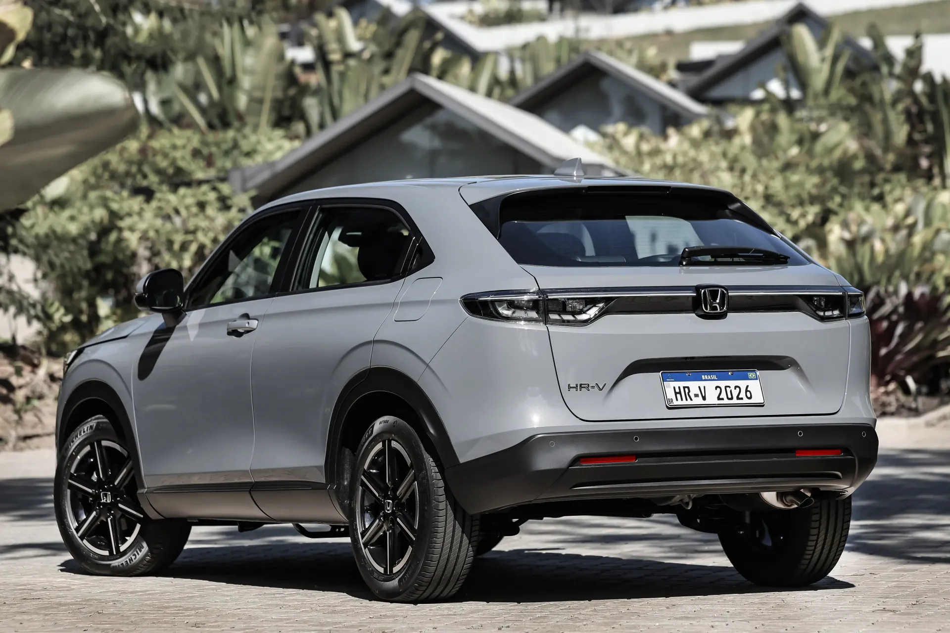 Gray electric SUV parked on a road with palm trees in the background