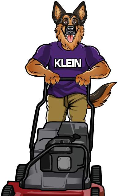 A german shepherd wearing a klein shirt is holding a blower