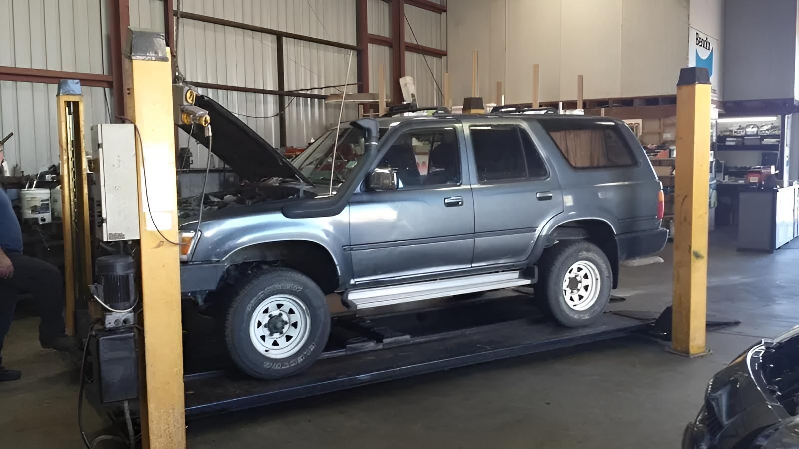 A Blue Suv is Sitting on a Lift in a Garage — Macquarie Brake & Automotive Services In Wauchope, NSW