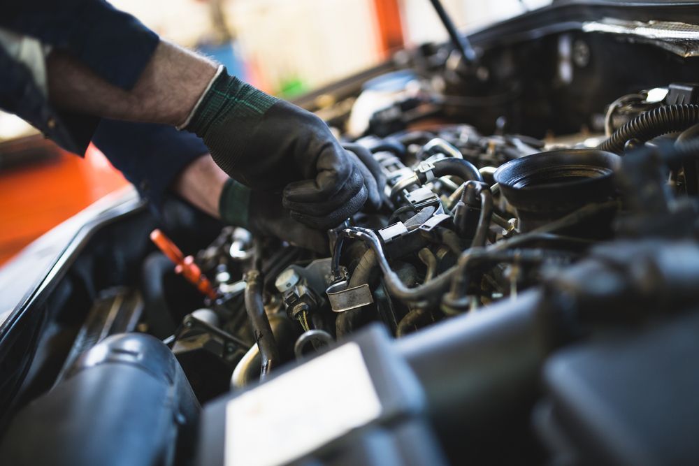 A Man is Working on the Engine of a Car in a Garage — Macquarie Brake & Automotive Services In Wauchope, NSW
