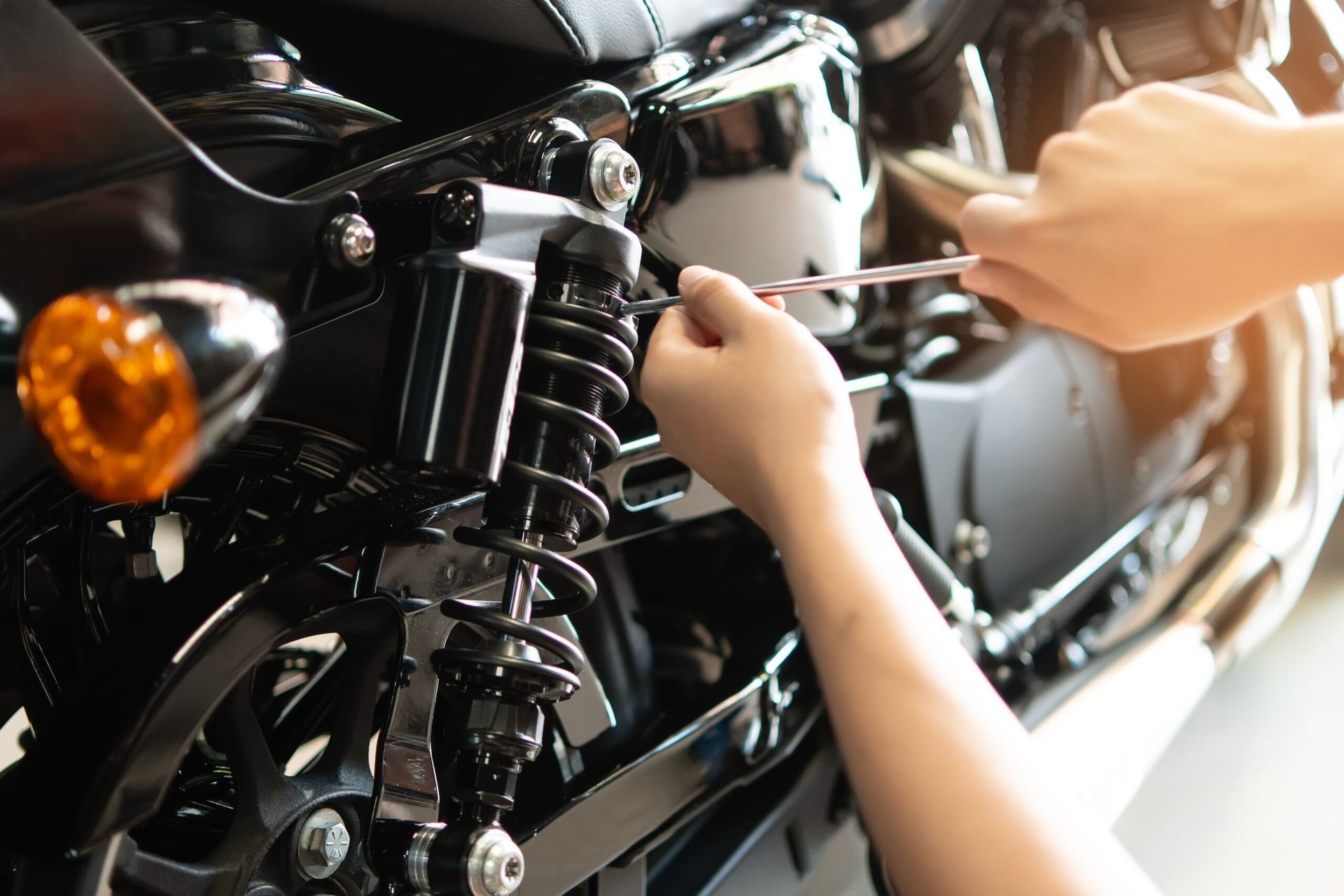 A Person is Working on a Motorcycle With a Wrench — Macquarie Brake & Automotive Services In Bonny Hills, NSW