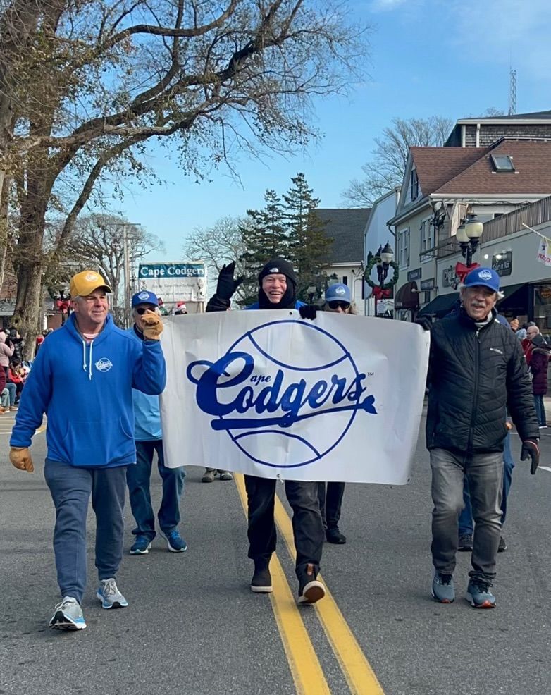 Four people march down a street holding a banner with the
