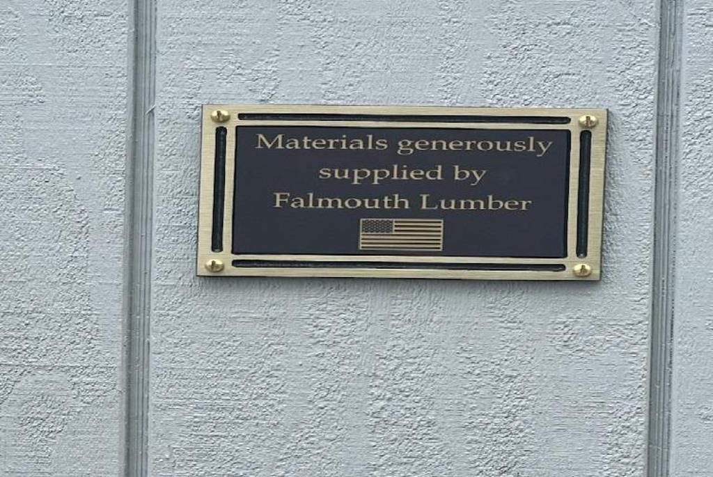 A black plaque with gold trim and lettering reads: 