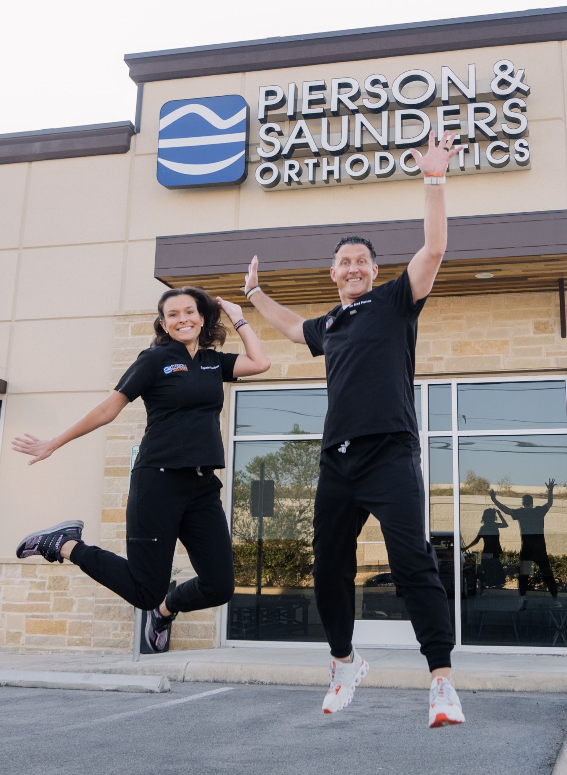 Doctors jumping in front of the office with excitement