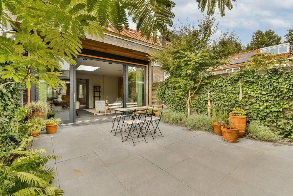 a patio with a table and chairs in front of a house .