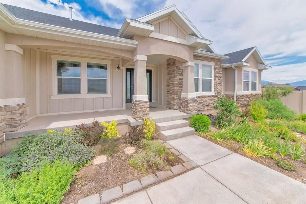 the front of a house with a concrete walkway leading to it .