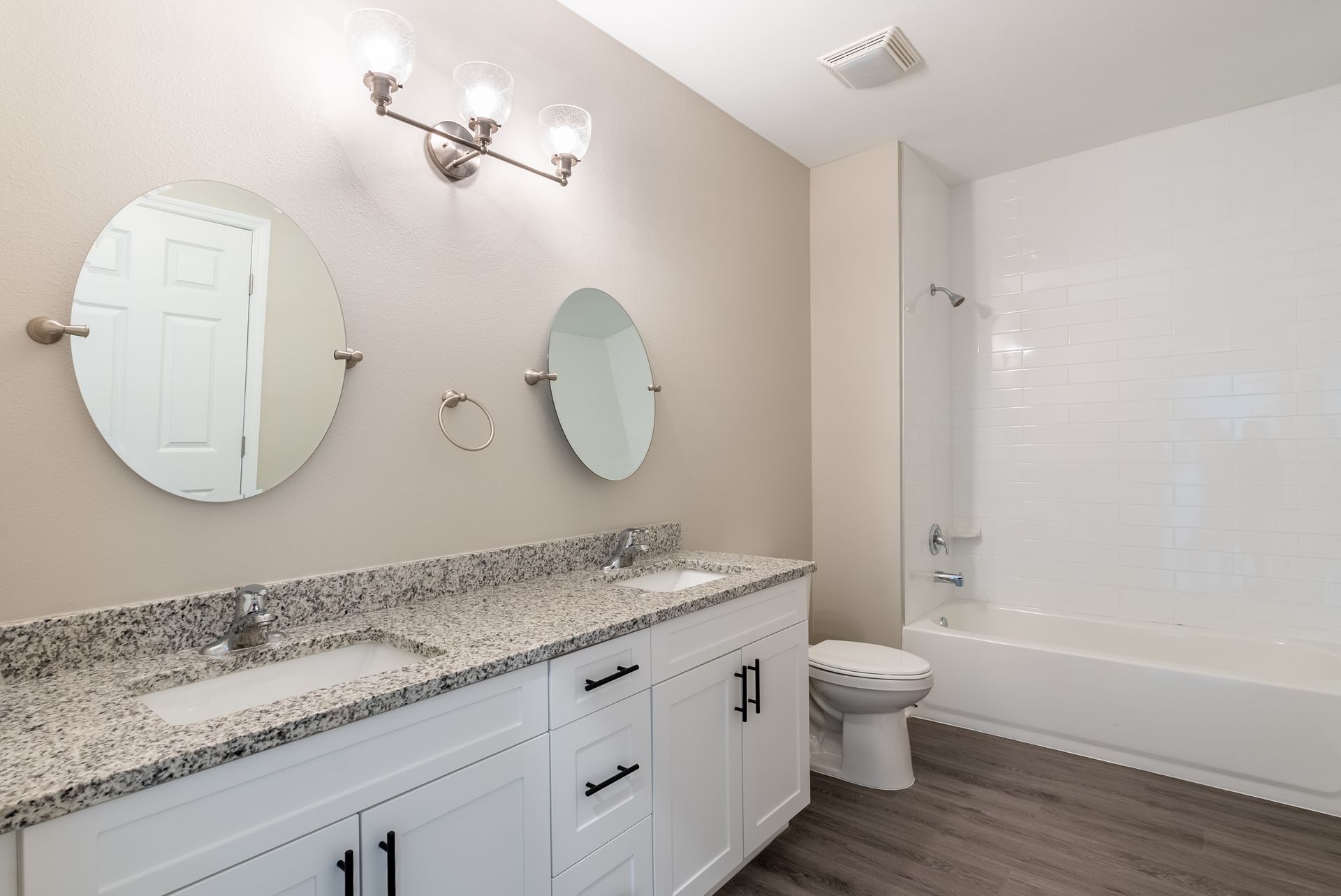 a bathroom with two sinks , a toilet , and a bathtub