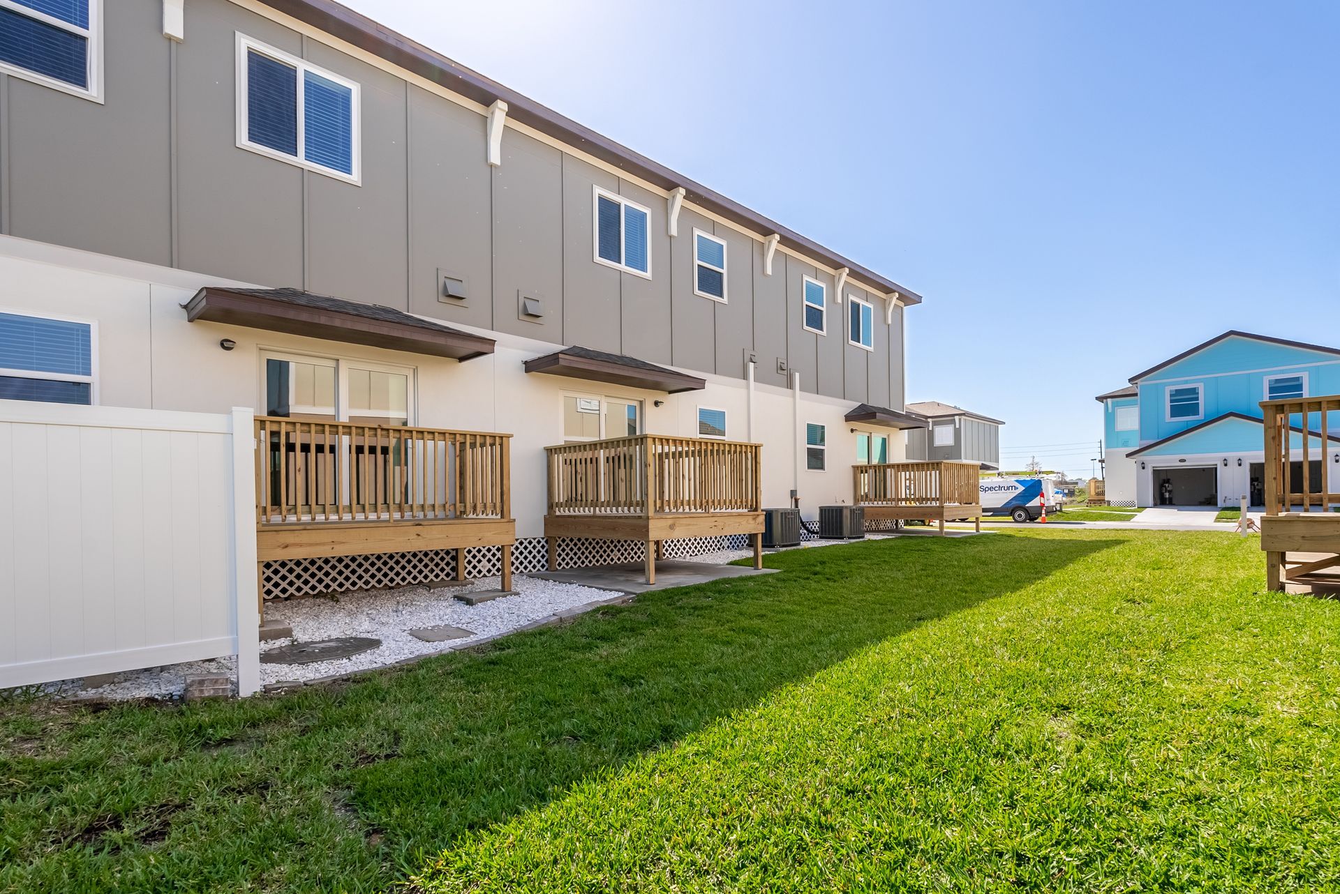 a row of town house balconies with a large lawn in front of them