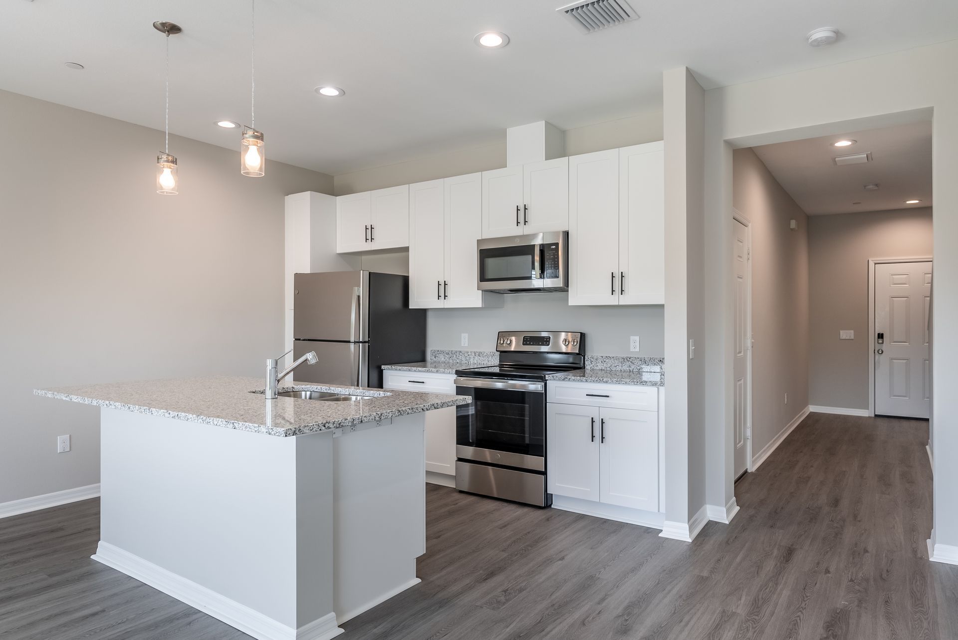 a kitchen with white cabinets and stainless steel appliances