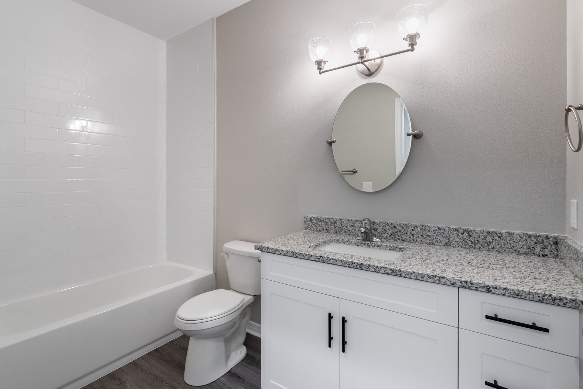 a bathroom with a toilet , sink , mirror and bathtub