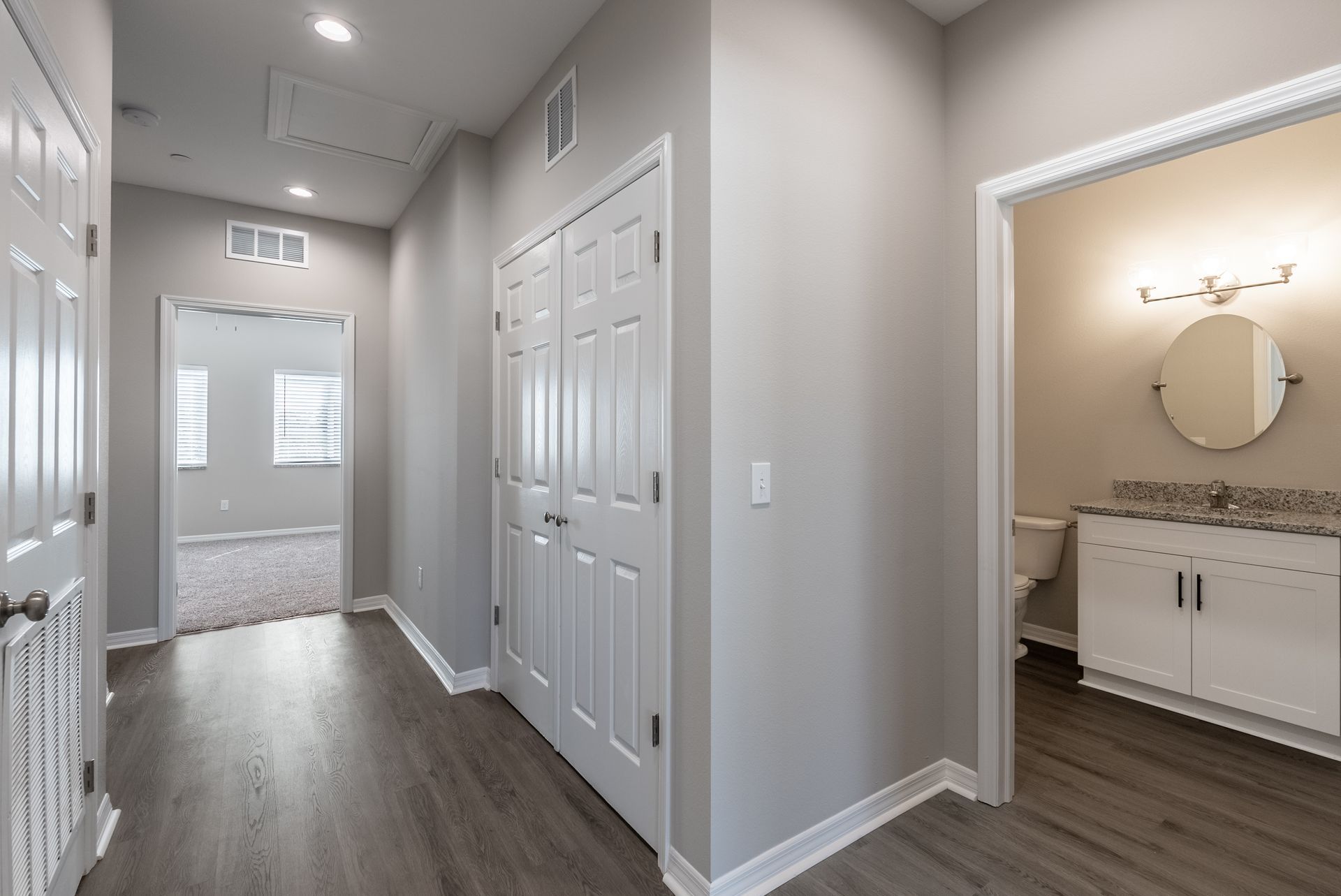 a hallway in a house with a bathroom and a closet