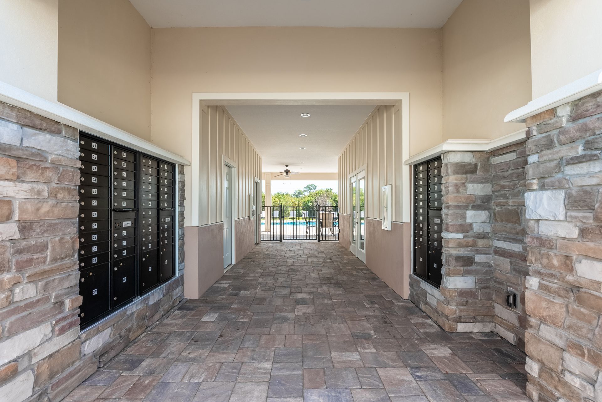 a long hallway with brick walls and mailboxes in a building