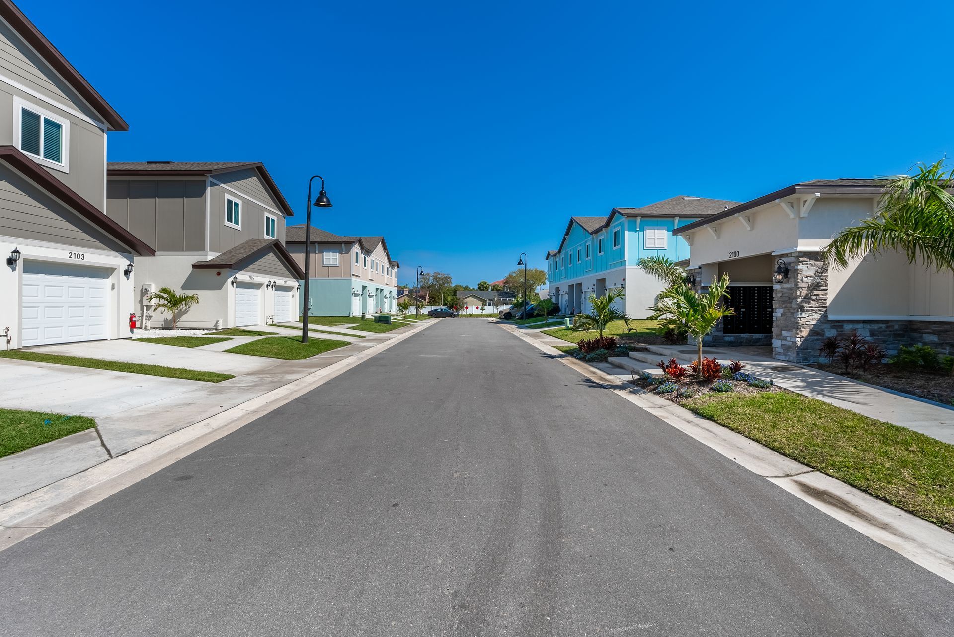 a row of townhomes are lined up on the side of a street .