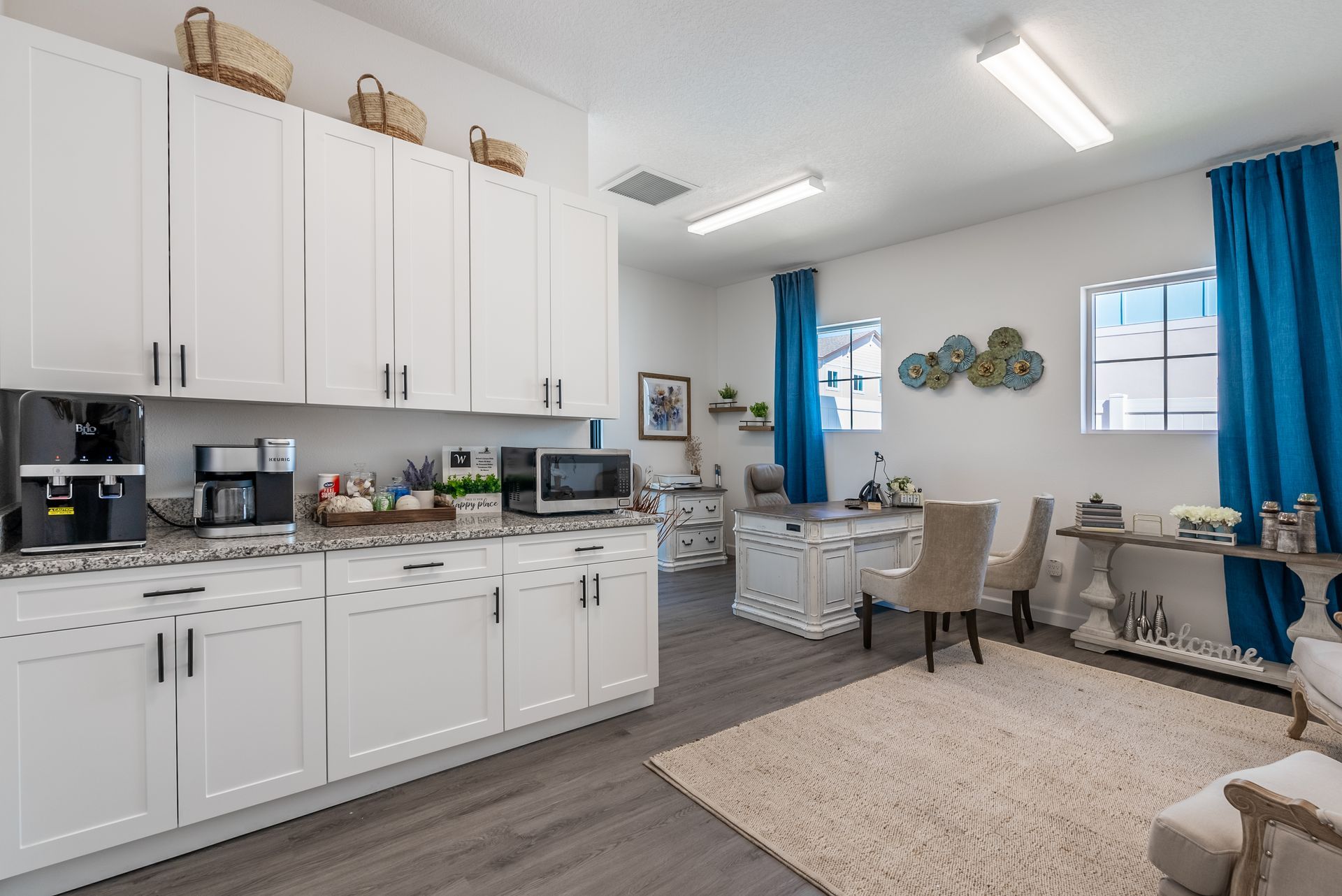 a kitchen with white cabinets , a microwave , and a coffee maker .