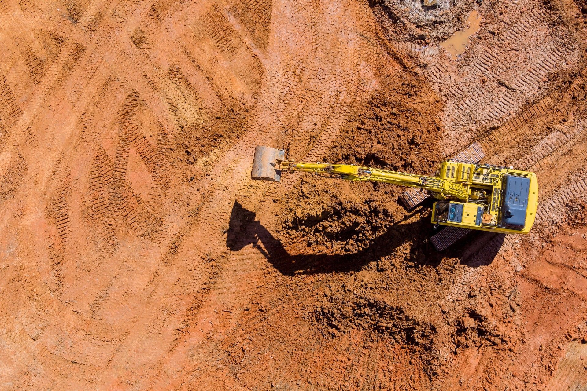 An aerial view of a bulldozer working in a dirt field.