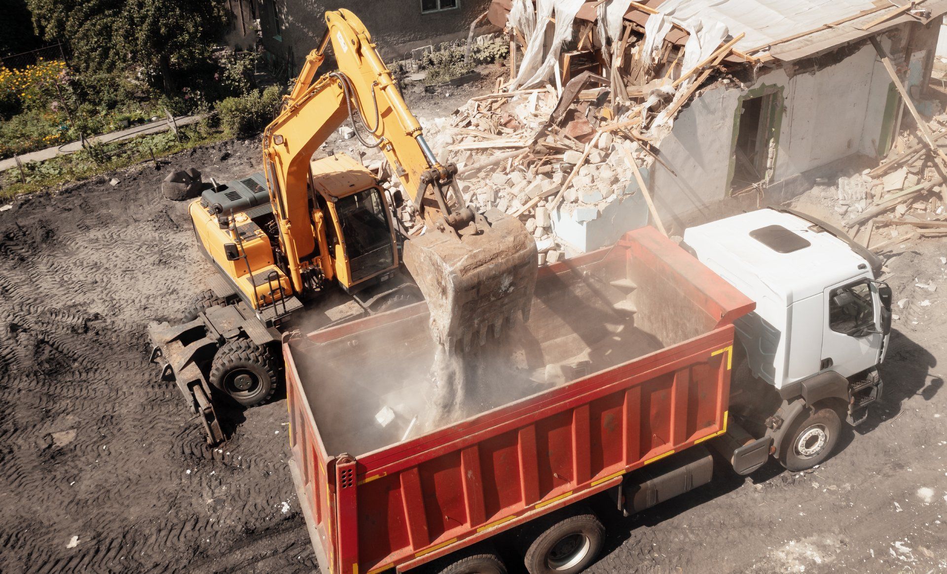 An excavator is loading dirt into a dump truck.