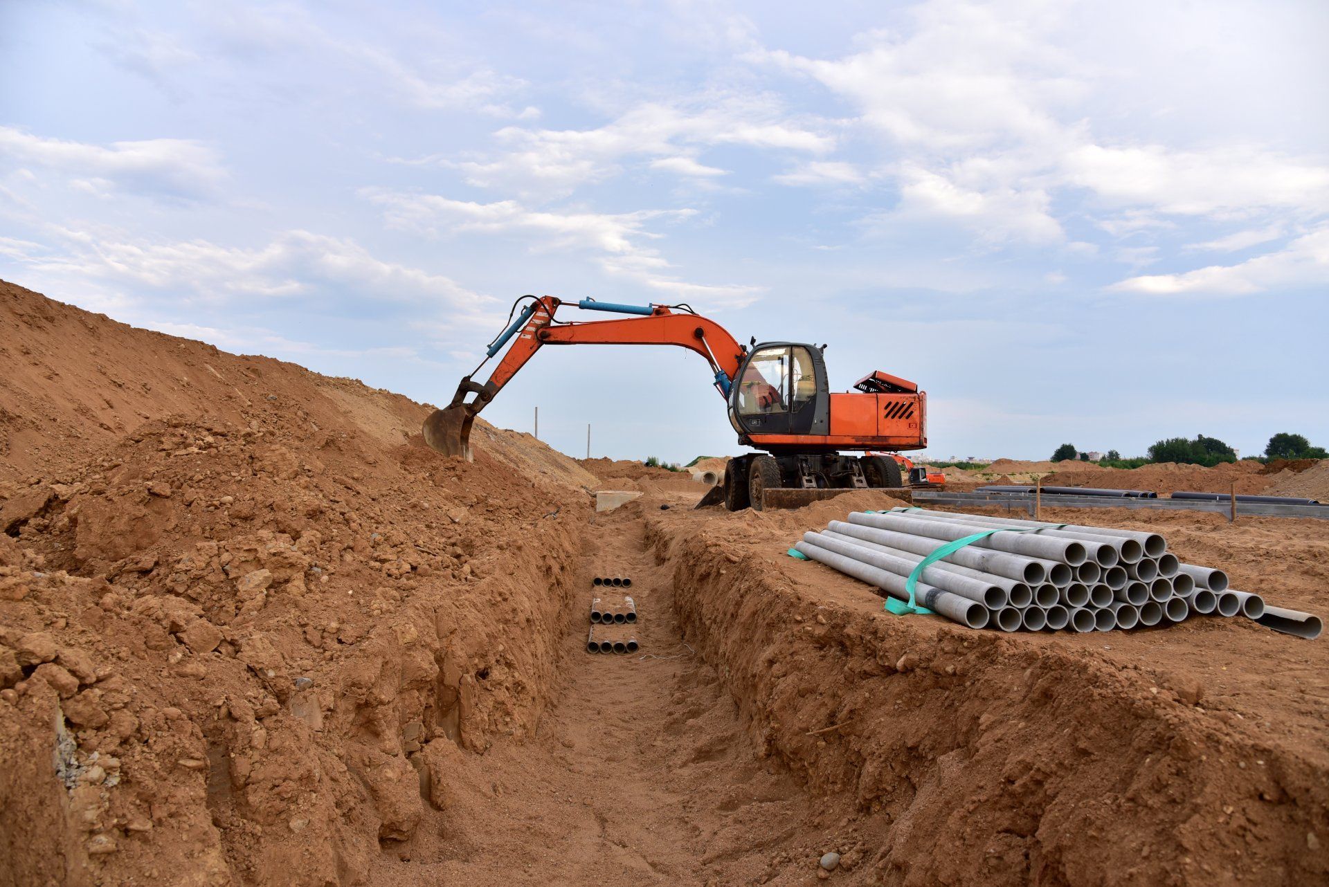 An excavator is digging a hole in the dirt at a construction site.