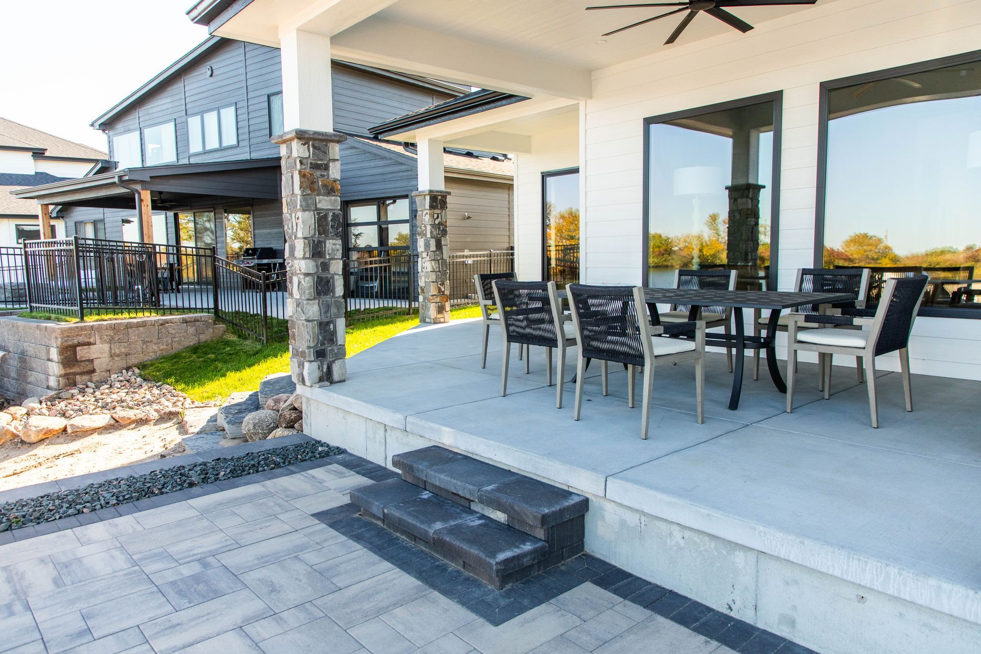 A patio with a table and chairs and a ceiling fan.
