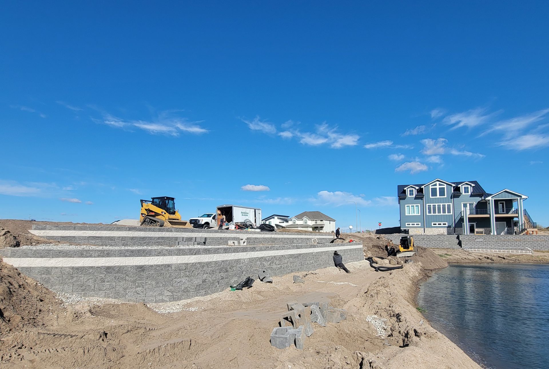 A large house is being built next to a body of water.