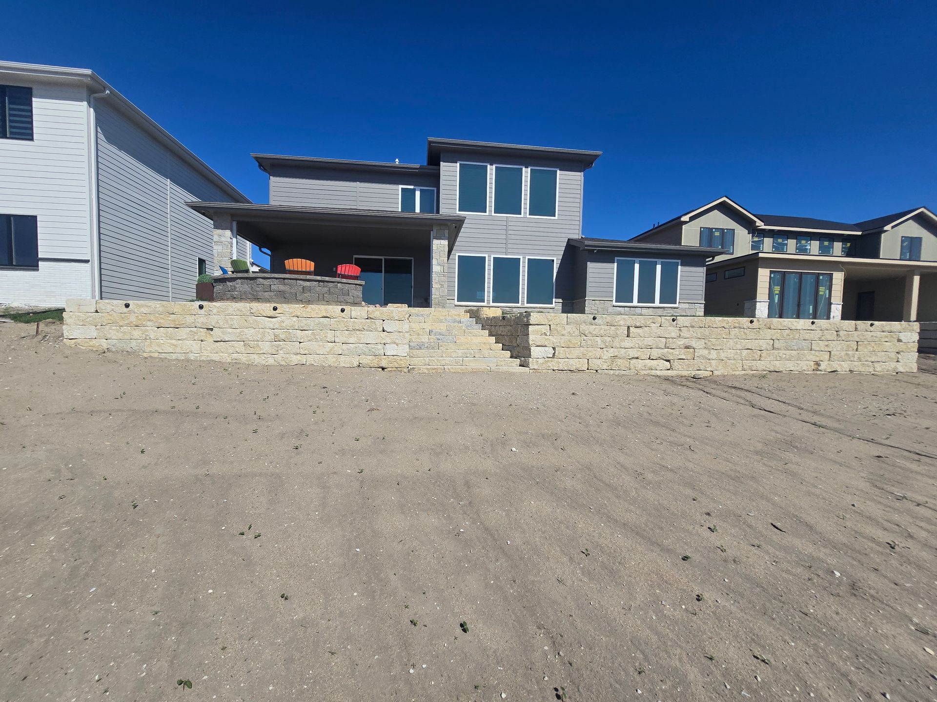A large house is sitting on top of a dirt hill