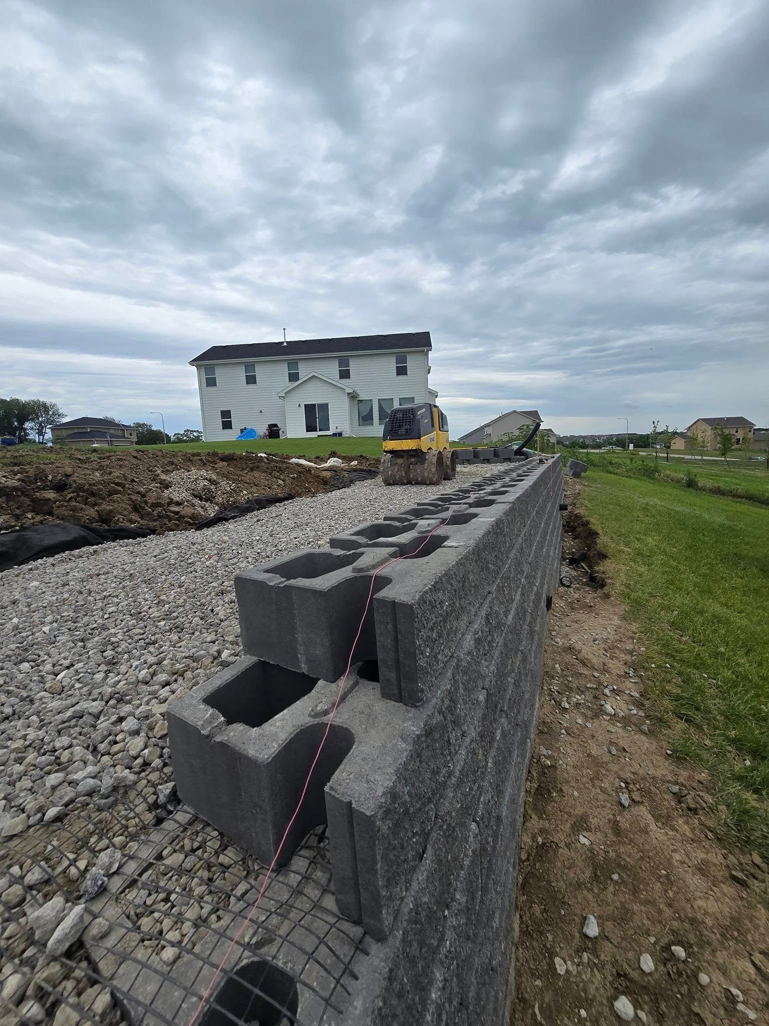 A brick wall is being built in front of a house.