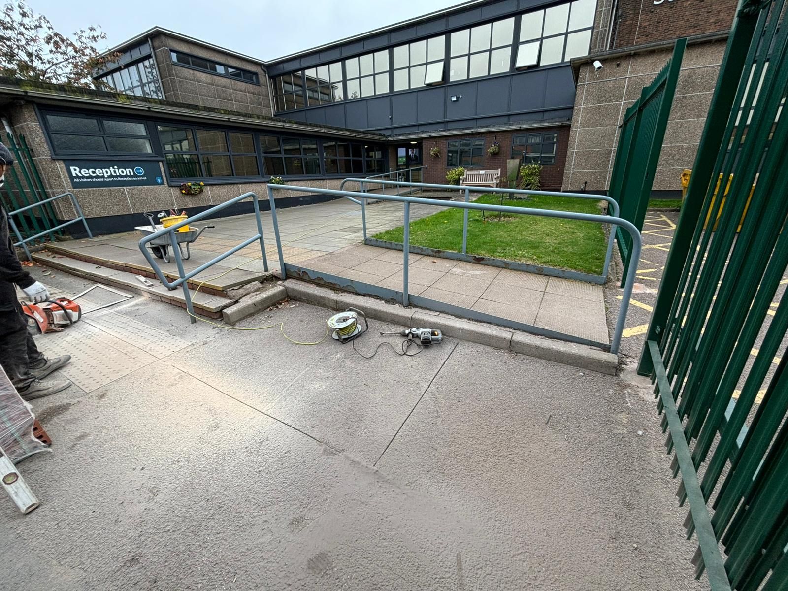Ramp and metal barriers outside a building entrance on a concrete walkway