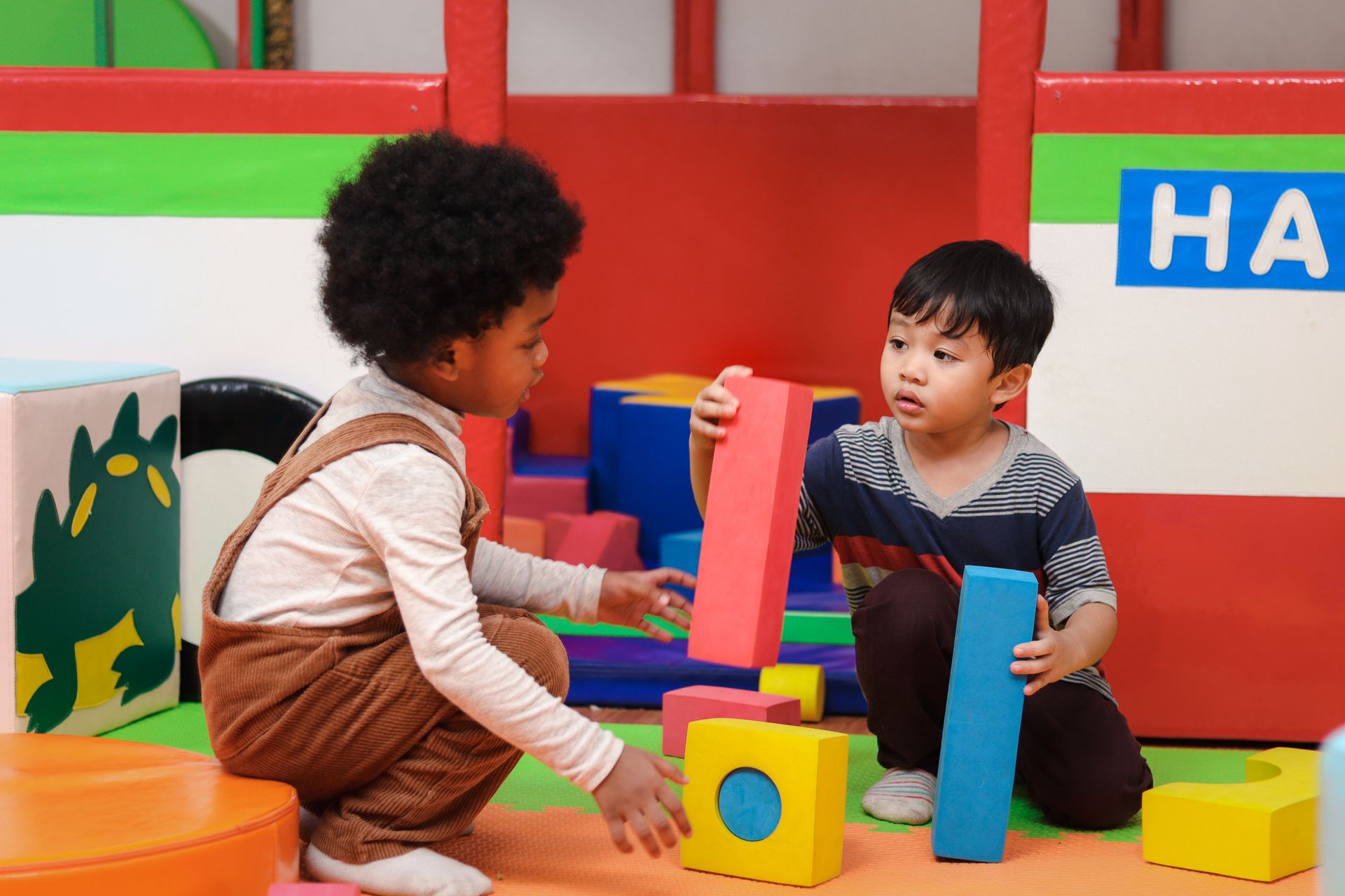 Two children playing with colorful blocks in a classroom play area