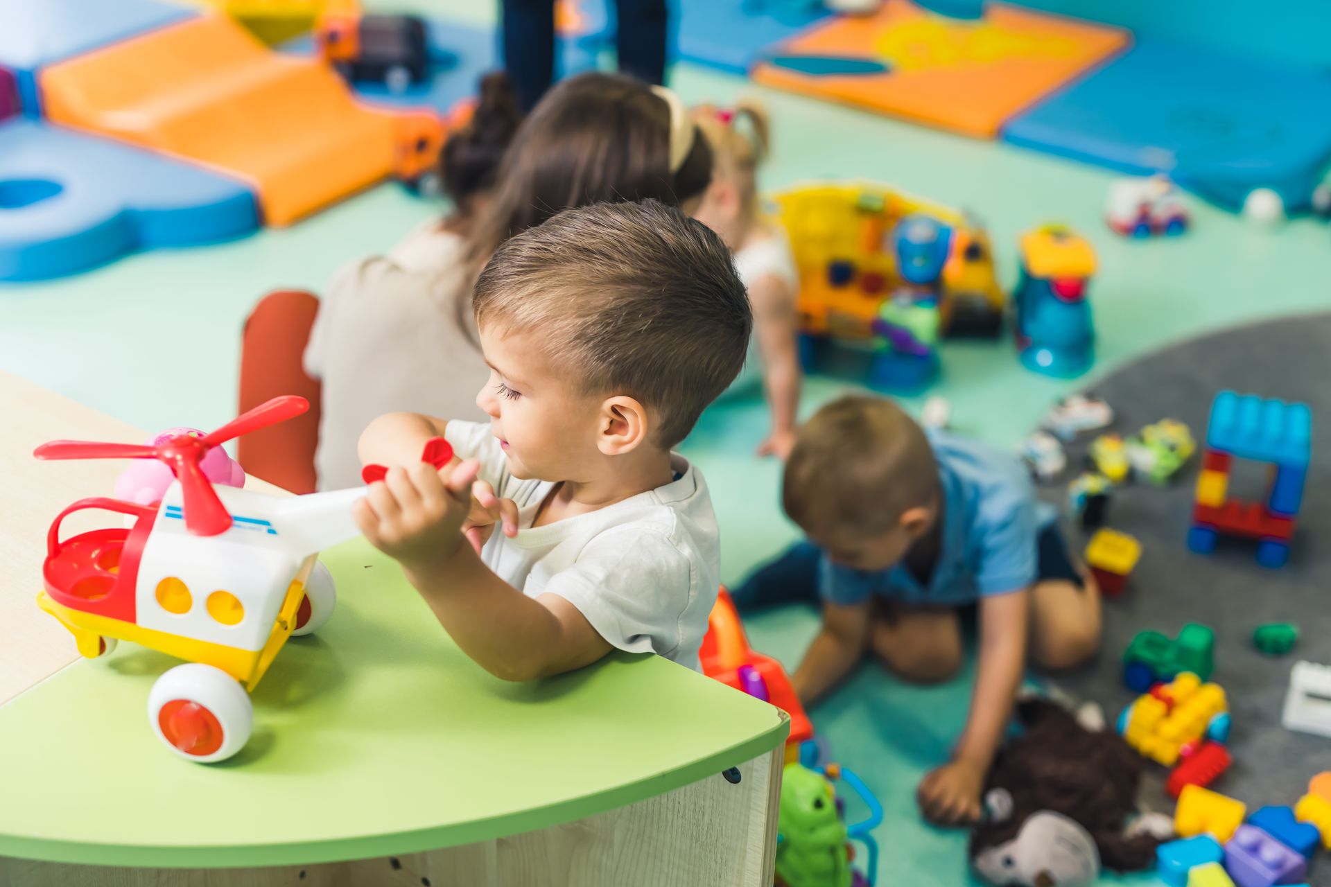 Children playing with colorful toys in a bright daycare room