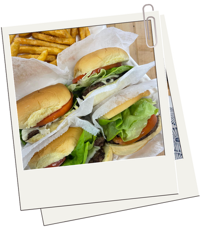 A polaroid picture of three hamburgers and French fries