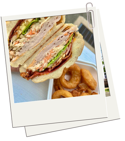 A polaroid picture of a club sandwich and onion rings
