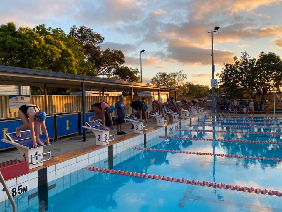 Swimmers lining up at the blocks