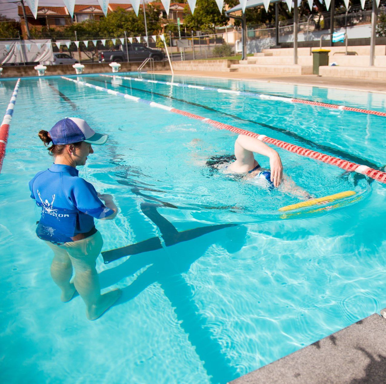 Coach in water teaching swimmer