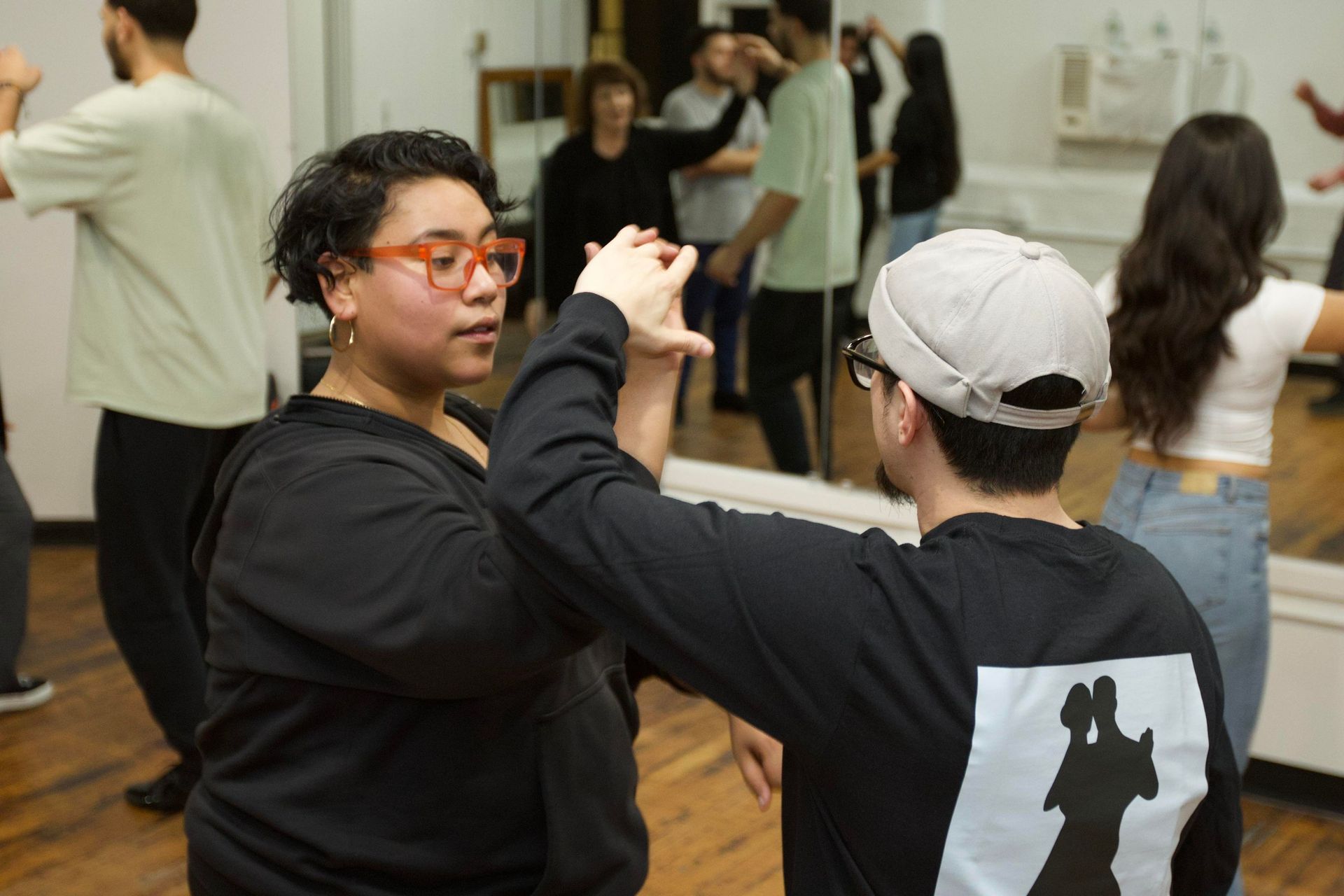 Instructor Brandon (a young Guatemalan man) dances bachata with instructor Kristy (a young Colombian woman).