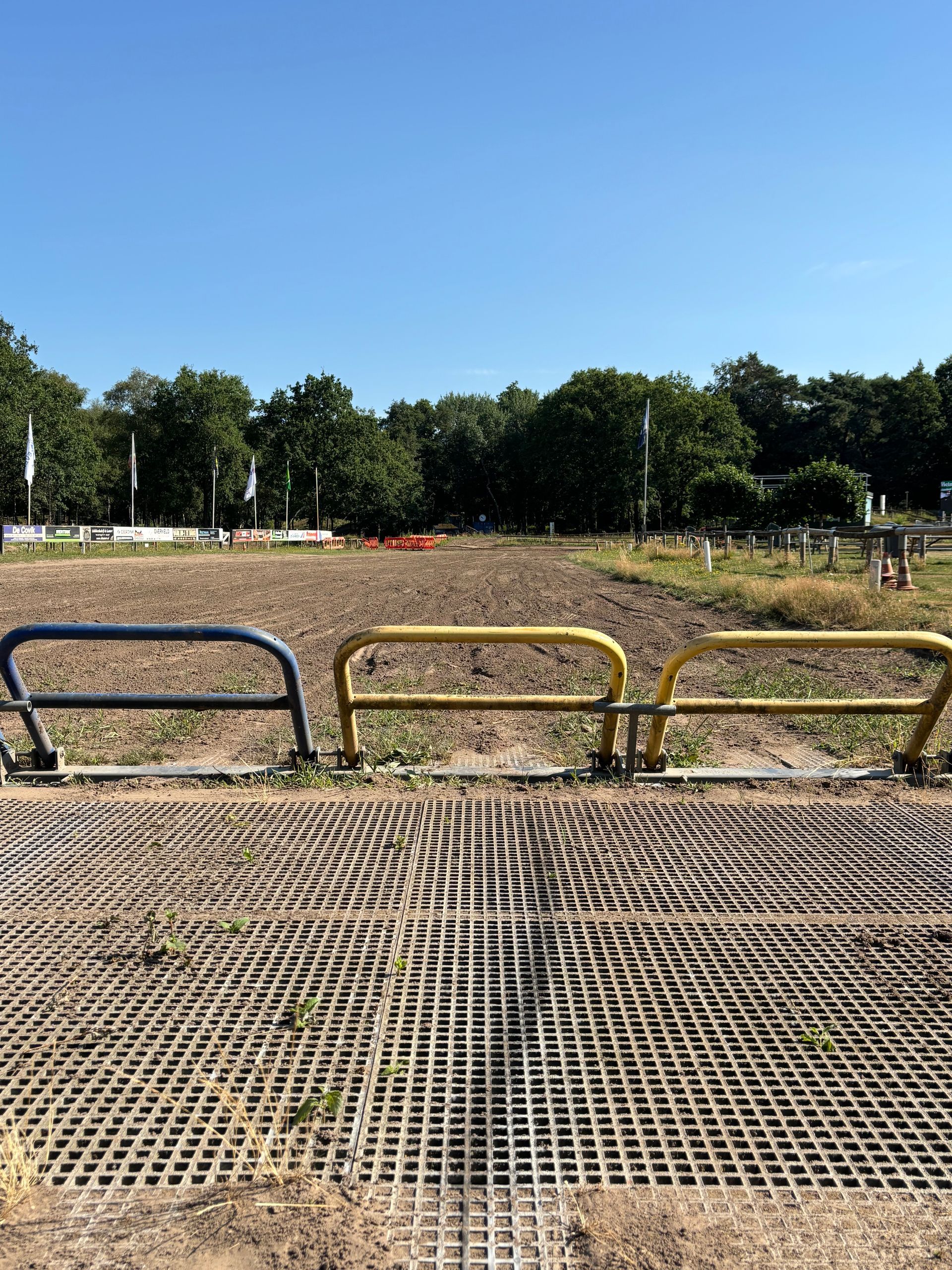 Yellow modular railing components shown in technical diagrams alongside an installed safety railing by a harbor.