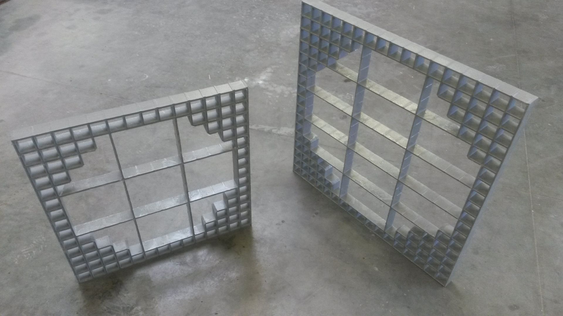 A top-down view of metal grating stairs with yellow railings leading to a work platform above water.