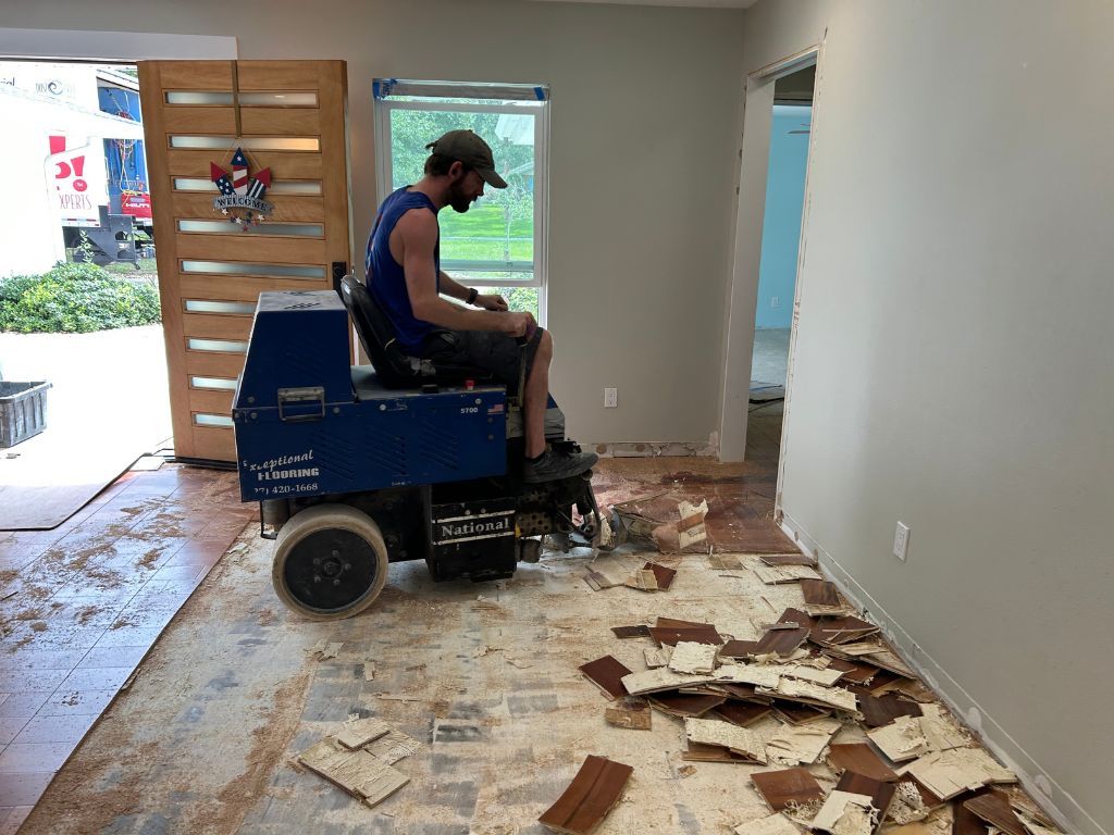 A man is sitting on a machine cleaning the floor of a room.