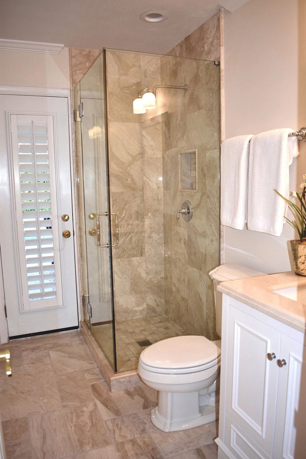 A bathroom with a toilet , sink , and walk in shower.