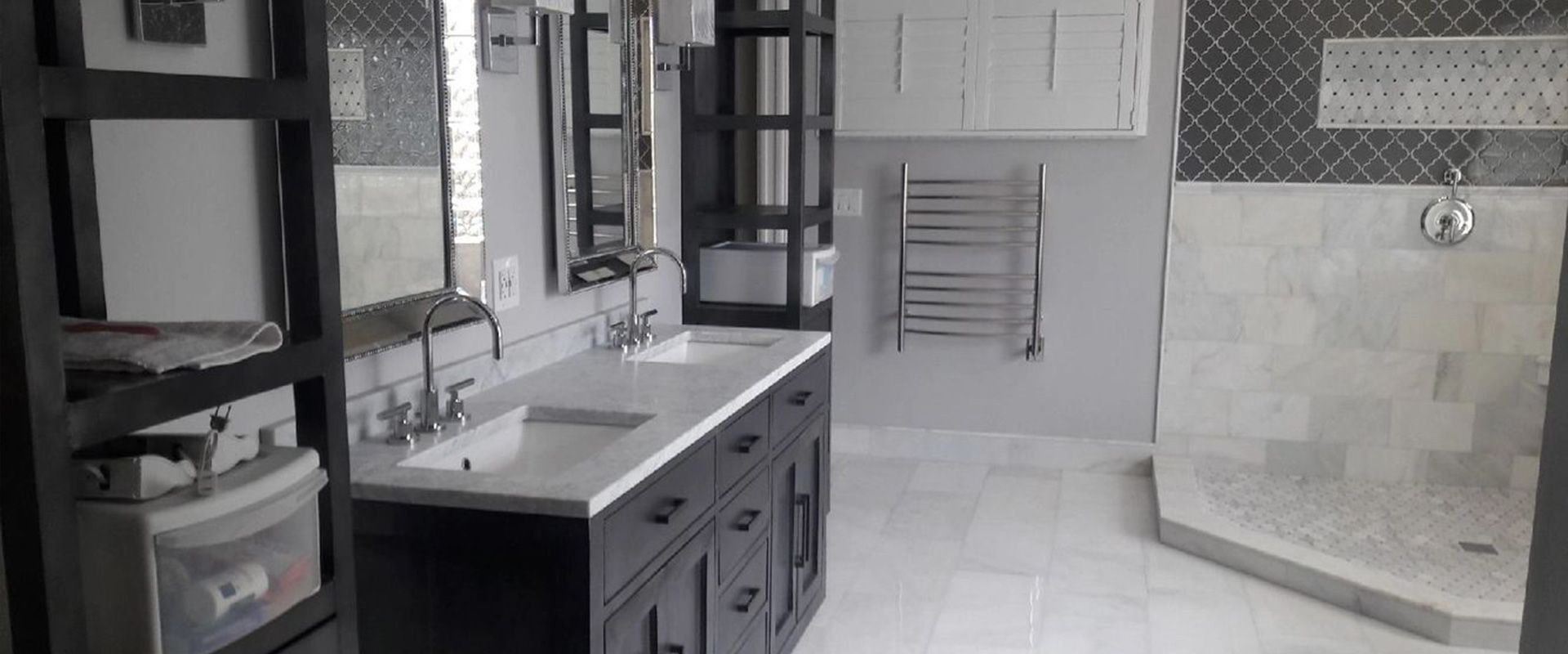 A bathroom with two sinks and a walk in shower.